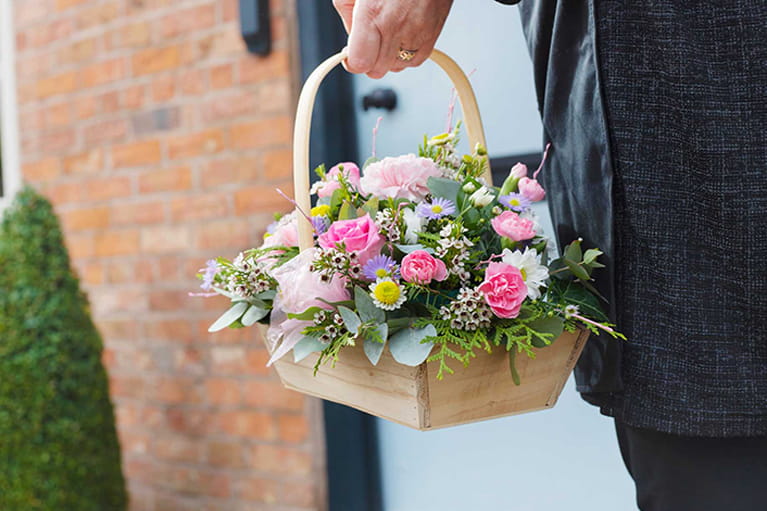 Florist delivering a basket flower arrangement