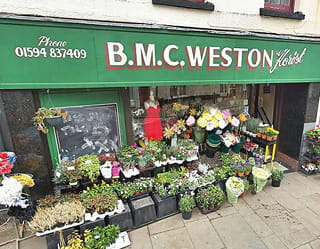 Independent florist shop displaying fresh flowers and plants outside the storefront