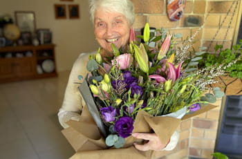Flower recipient holding a freshly delivered bouquet