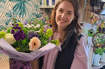Local florist holding a freshly arranged bouquet