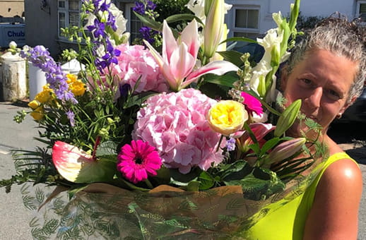Local florist holding flowers outside a flower shop