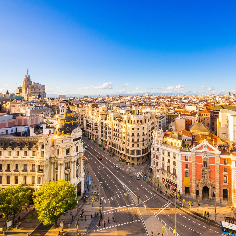 Madrid cityscape with Gran Vía's historic buildings and bustling streets.