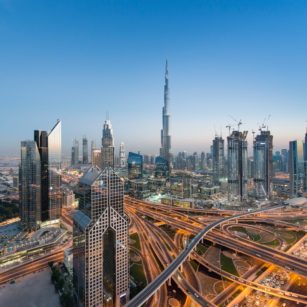 Dubai skyline featuring the Burj Khalifa, modern skyscrapers, and a network of highways.