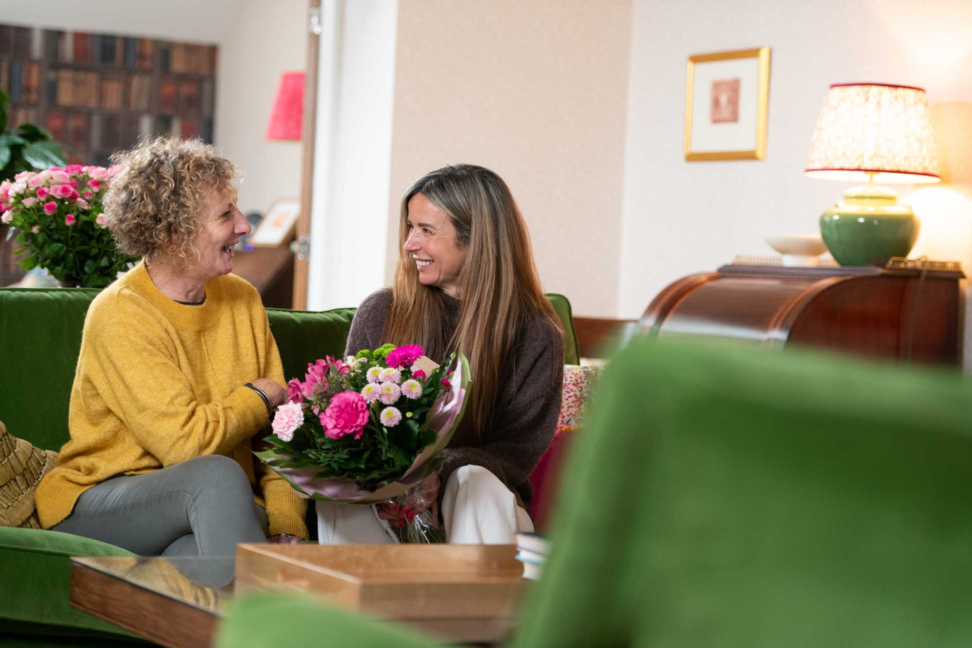 Friends enjoying conversation with flowers on table in front