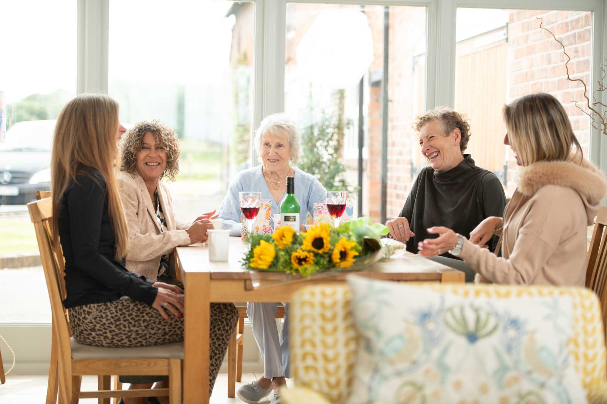 Bouquet of congratulations flowers displayed while friends talk and drink wine