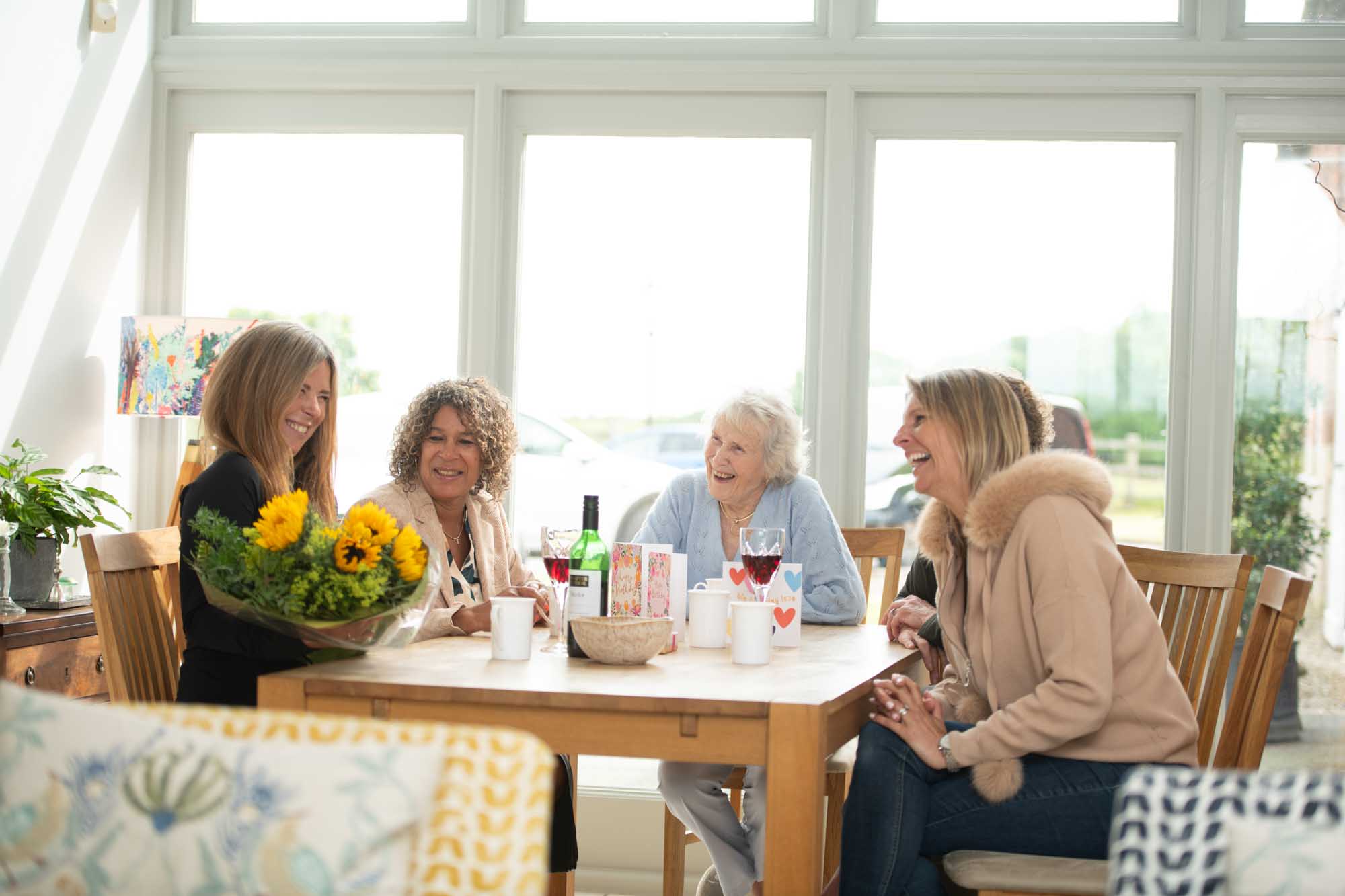 family chatting around the table, flowers proudly on display
