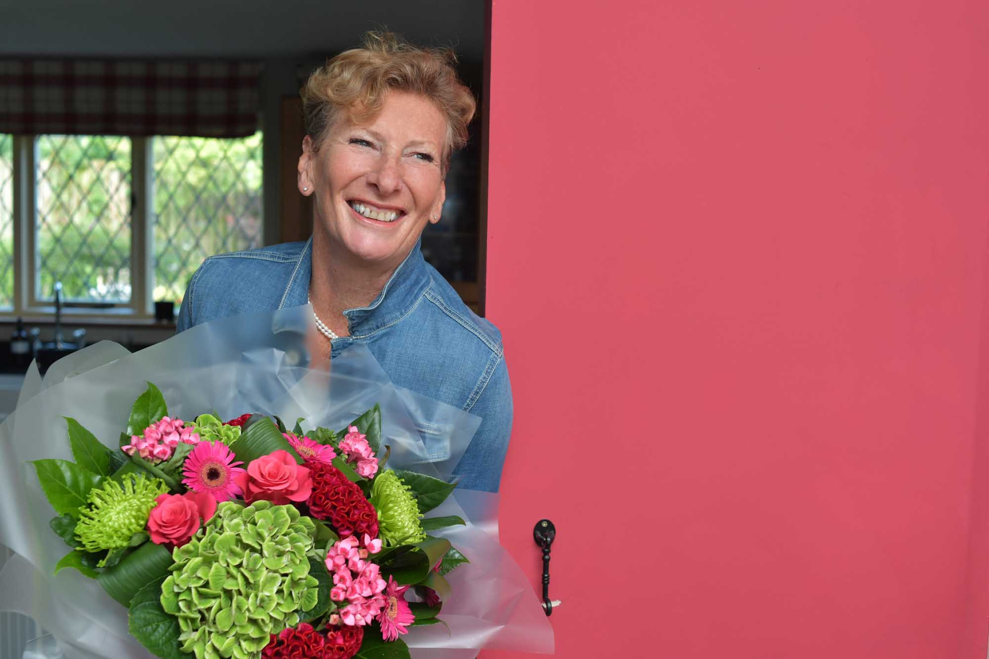 Summer bouquet delivered by local florist to woman at the door