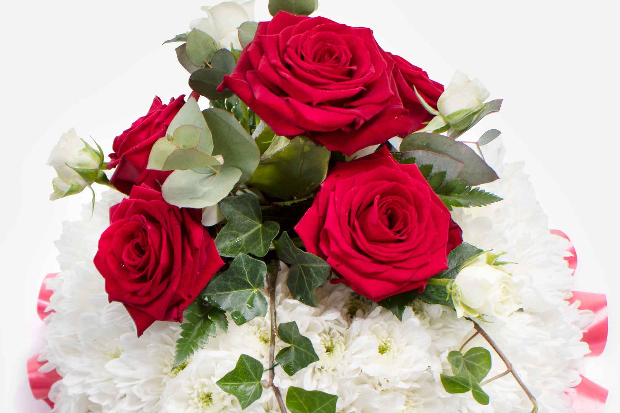 Close-up of a small funeral posy with white chrysanthemum and red roses on a white background