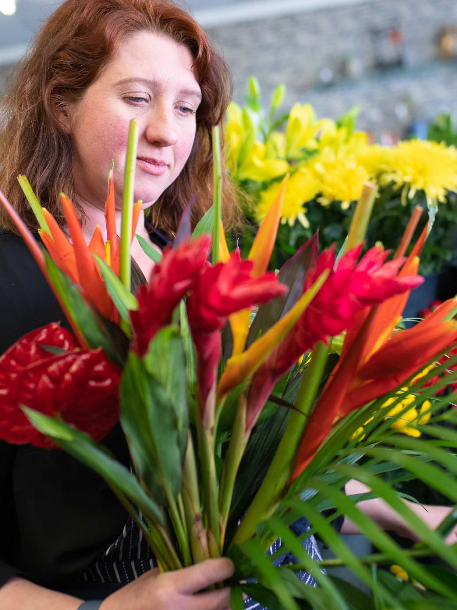 Florist selects exotic flowers including anthurium from the flower stand.