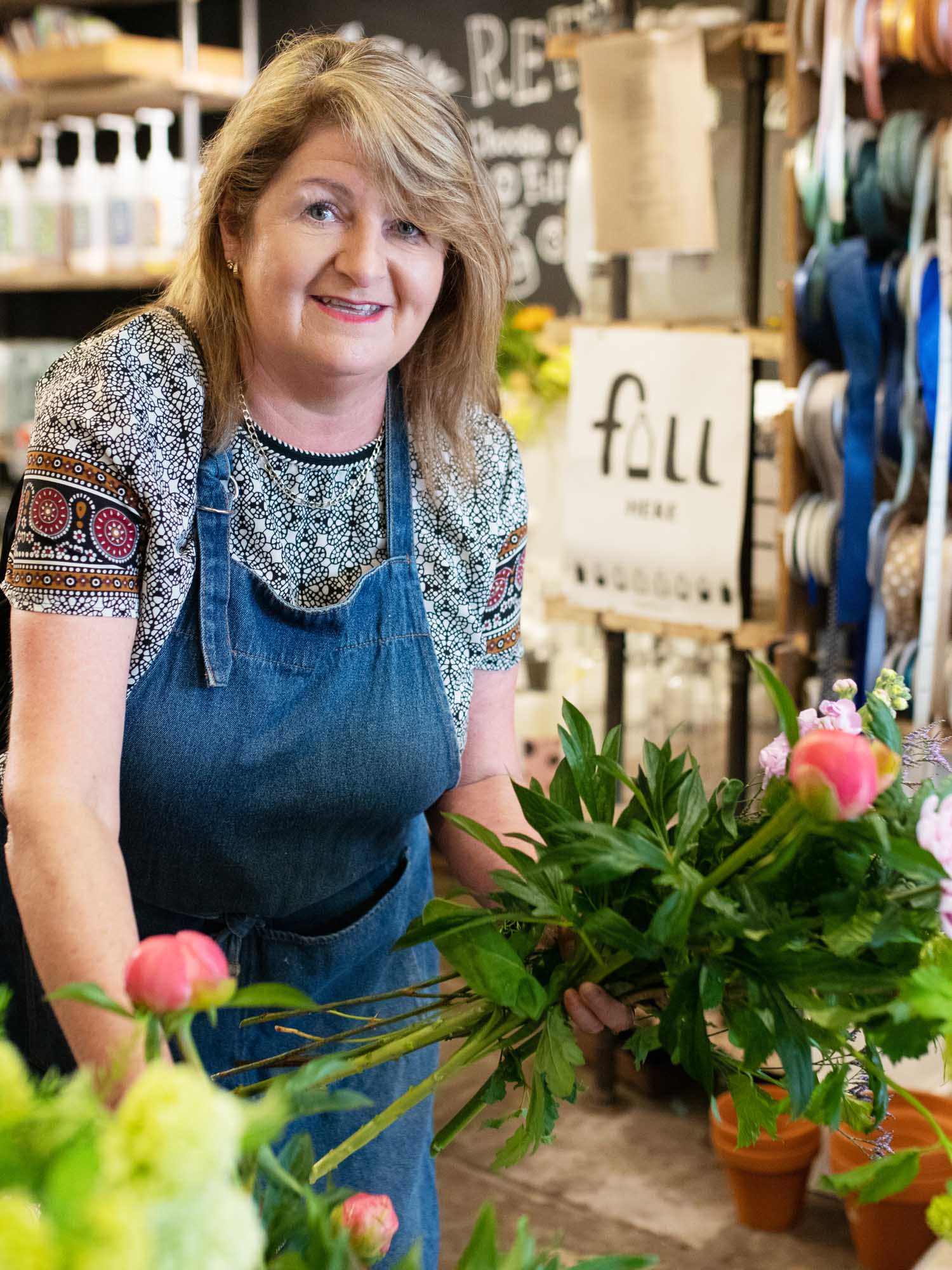 Smiling florist making a bouquet with a selection of flowers