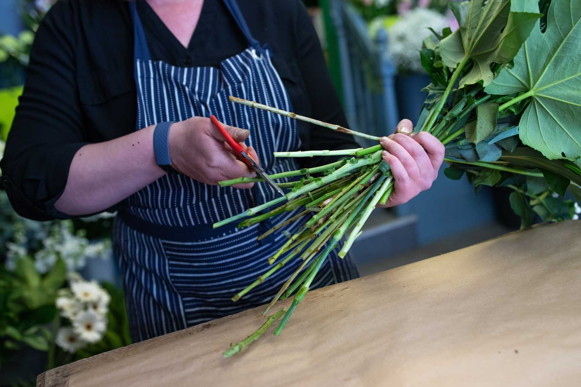 Florist works diligently on the engagement bouquet, image shows how much love care and attention goes into each bouquet arrangement