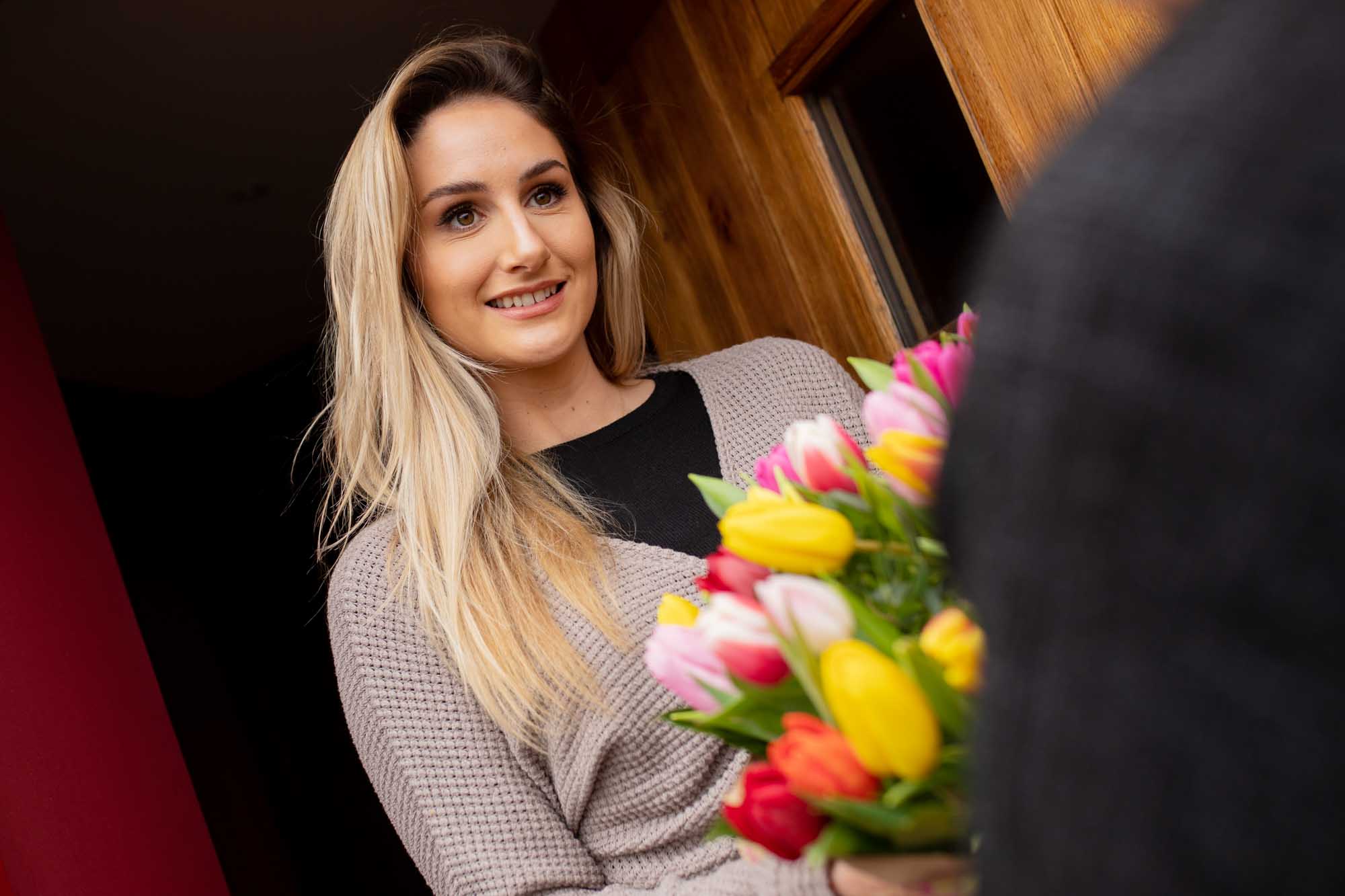 Smiling lady receives bouquet of tulips