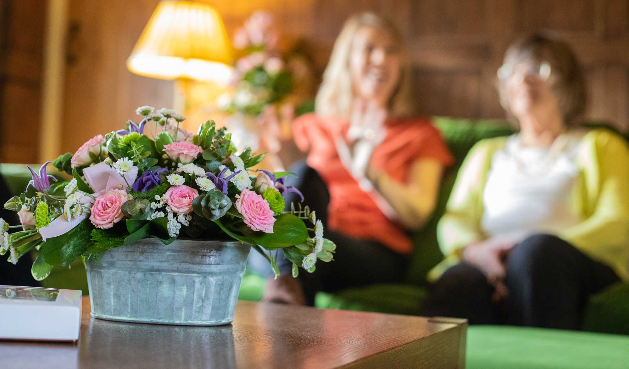 Young woman smiling and looking at the vibrant flowers being delivered to her