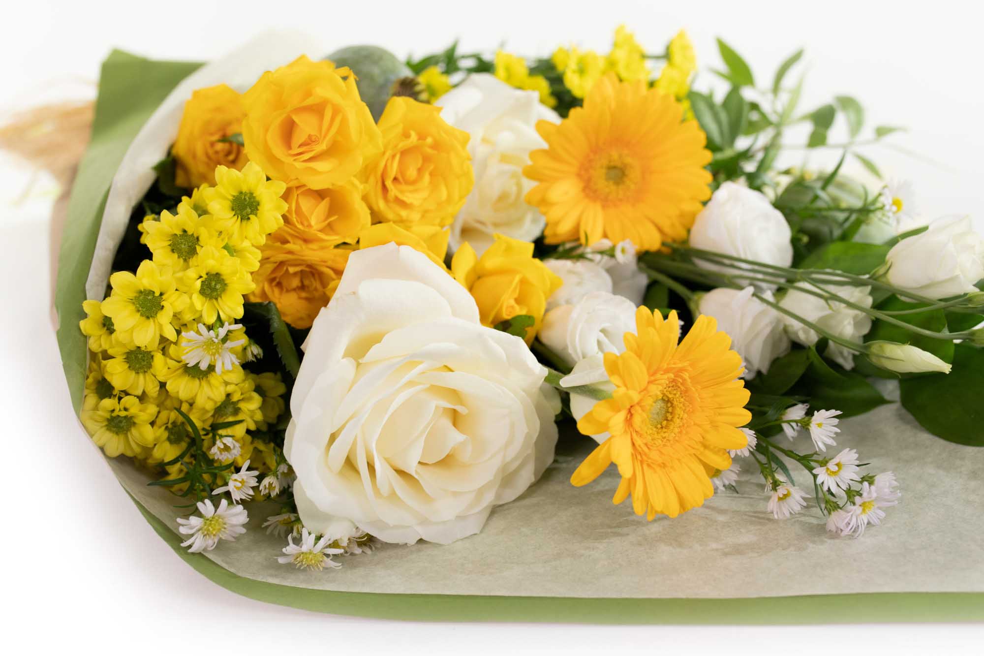 Bouquet of yellow roses, white roses, yellow daisies, and greenery wrapped in paper on a white background