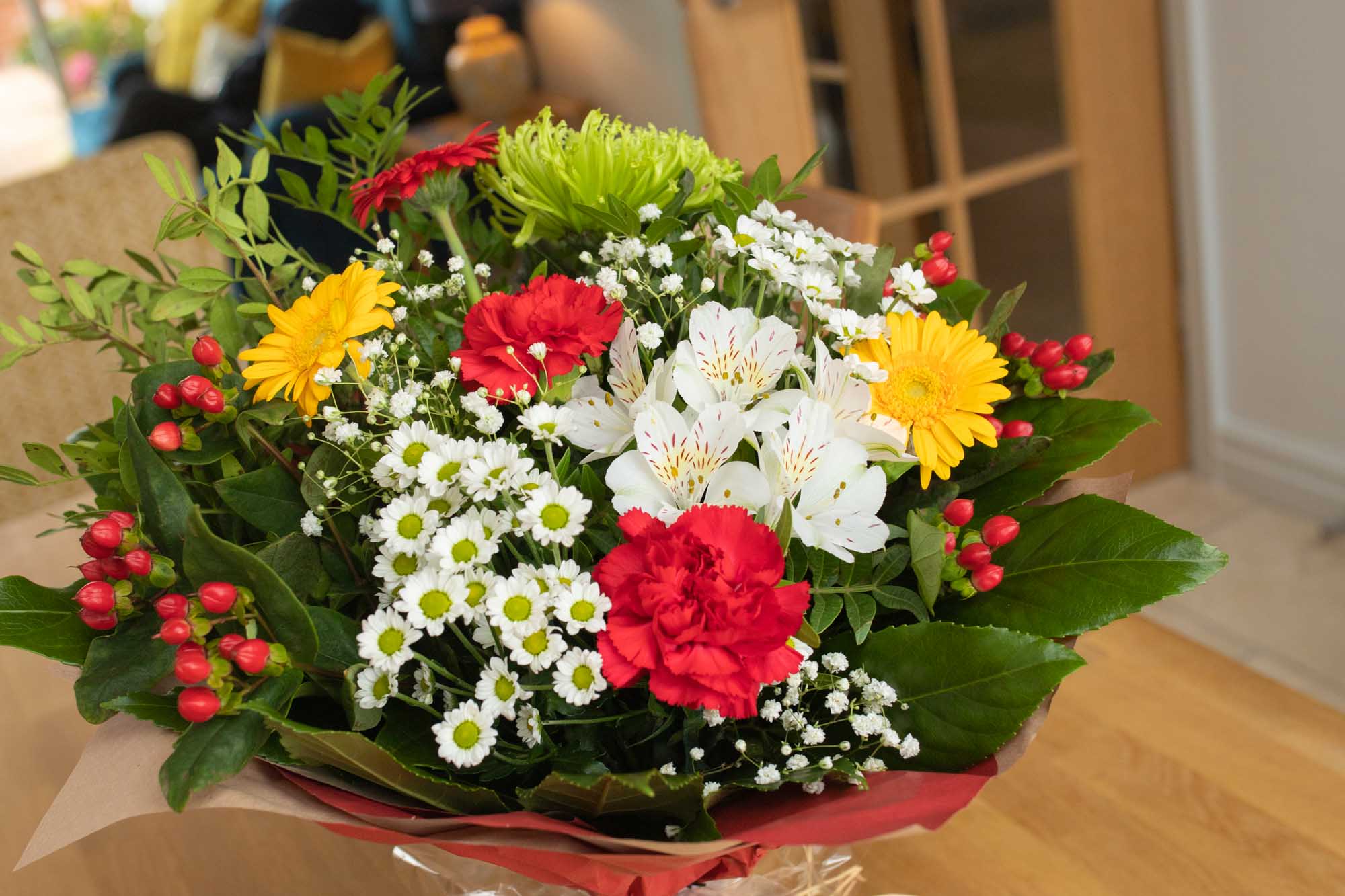 Close up of a Christmas themed bouquet feauturing red, white and yellow flowers