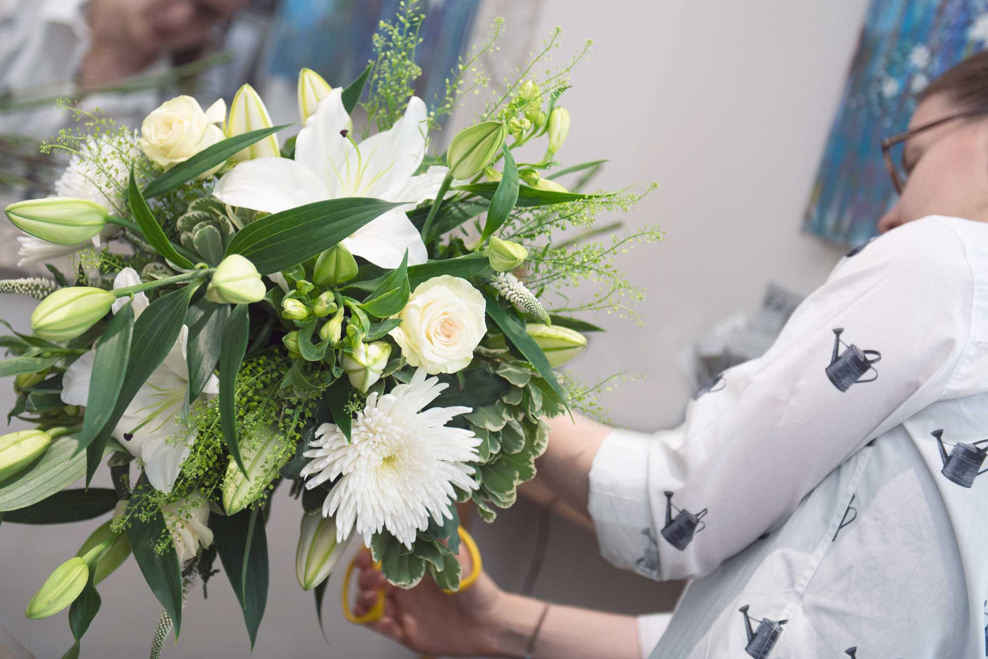 Florist making a serene white lily arrangement