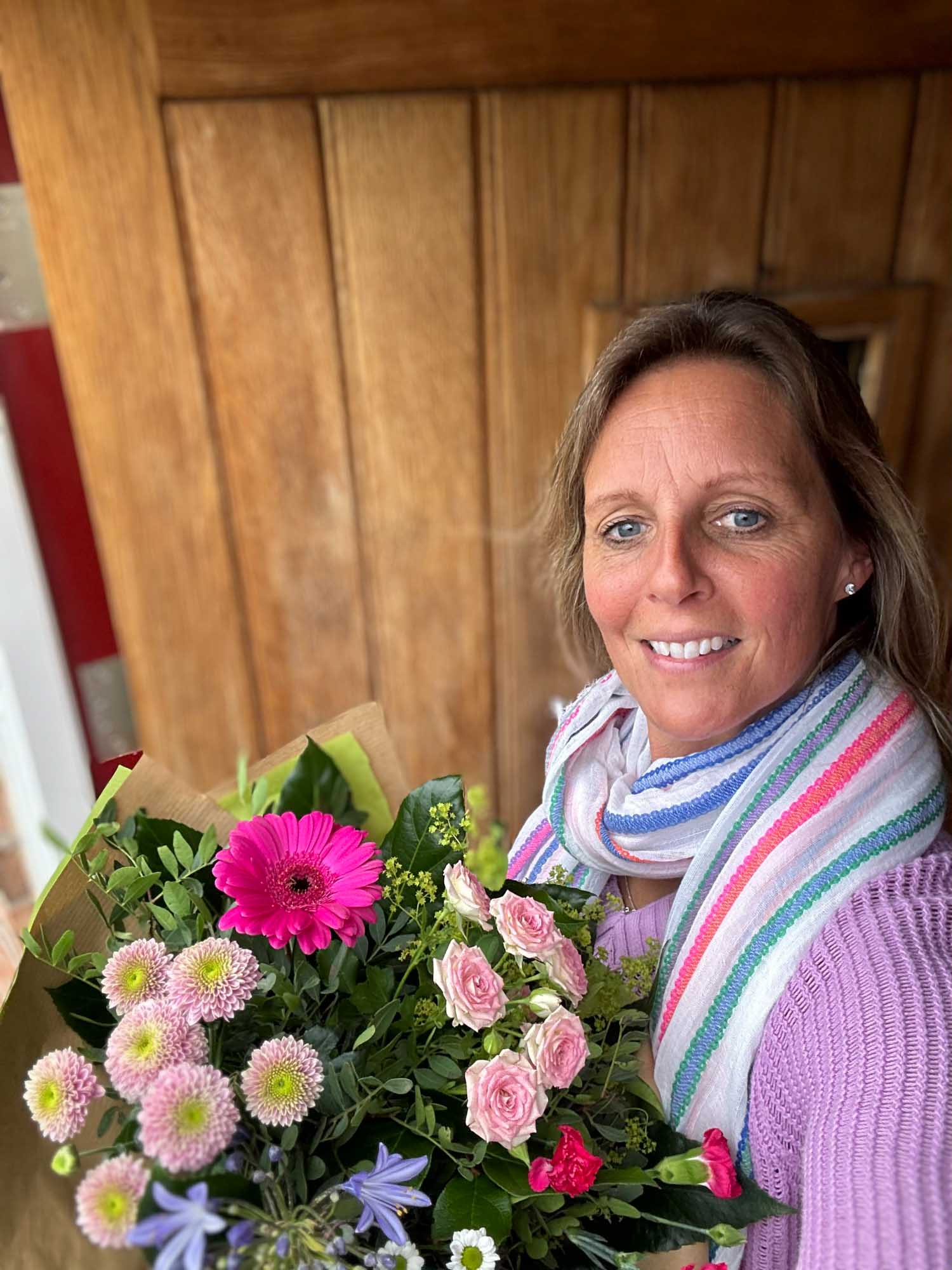 Wife holding flowers at the door of her house in Ireland
