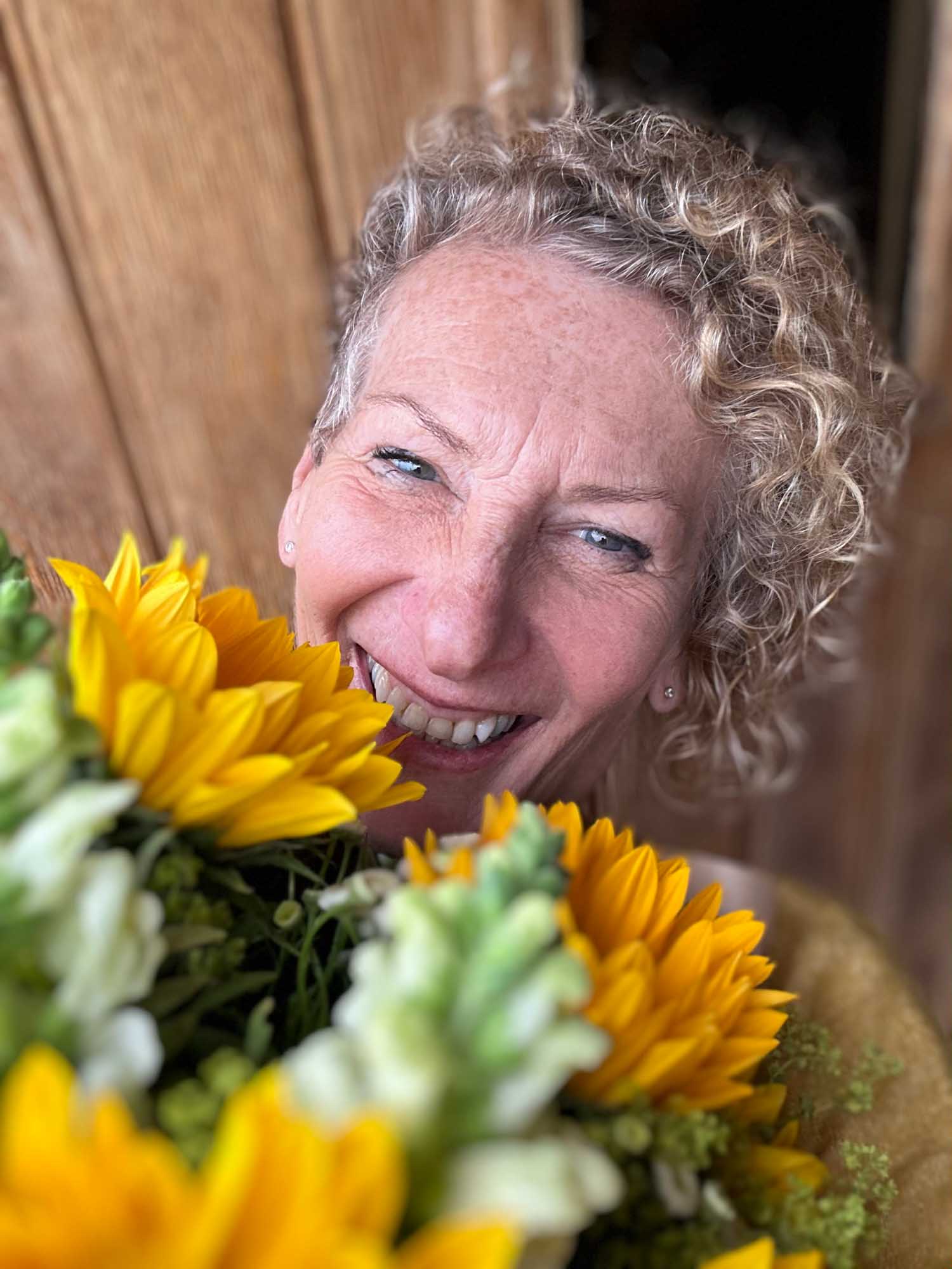 Selfie of a happy woman smiling hugging her delivery of sunflowers